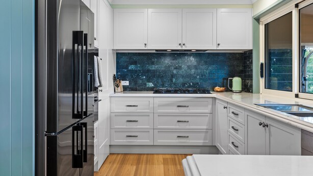 A modern kitchen with white cabinetry, a stainless steel refrigerator, and a black backsplash. - Heavenly Hideaway at Lovedale Private Pool and Spa (Allandale)