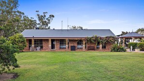 A brick building with a flat roof, large windows, and a small porch area. - Heavenly Hideaway at Lovedale Private Pool and Spa (Allandale)