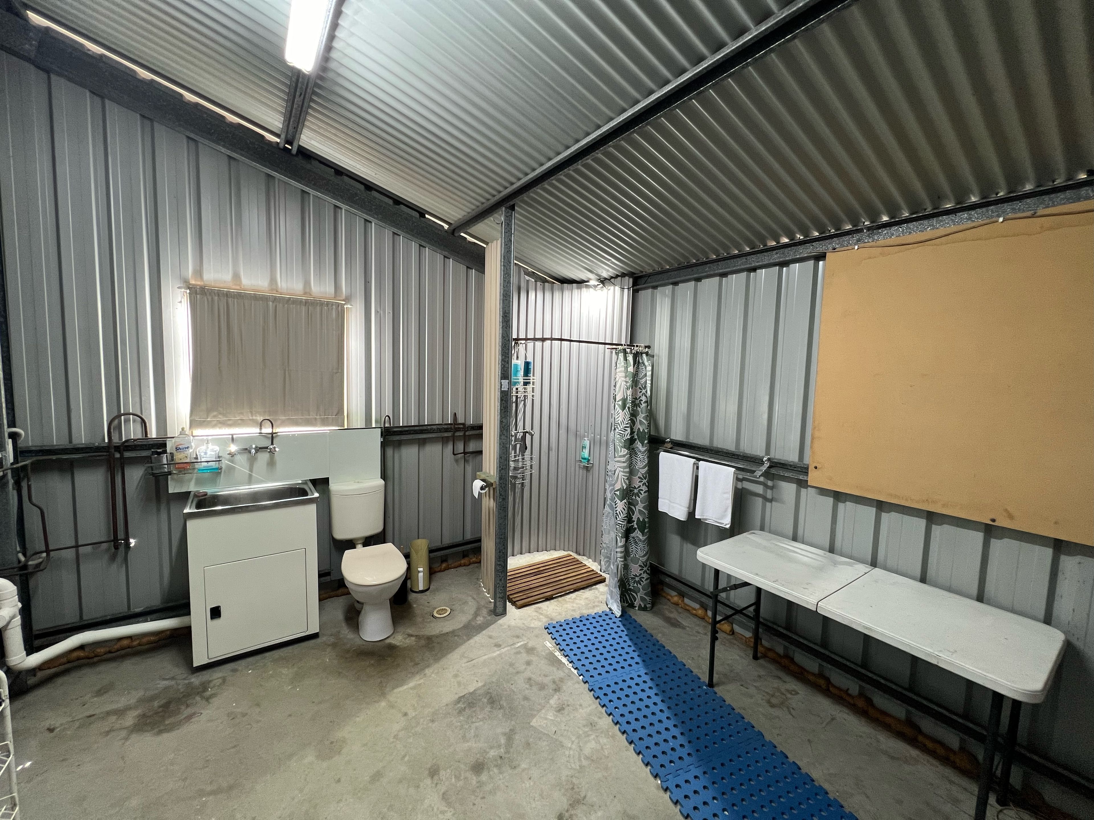 Une petite salle de bain comprenant des toilettes, un lavabo et un espace douche.