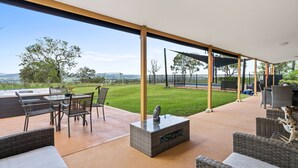 An outdoor patio area with a table, chairs, and a fire pit. - Heavenly Hideaway at Lovedale Private Pool and Spa (Allandale)