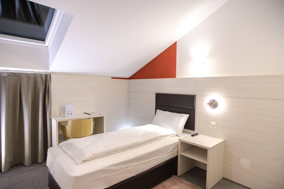 Ein modernes Hotelzimmer mit einem Bett, einem Schreibtisch und einem kleinen Tisch.