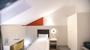 Un dormitorio moderno con cama, escritorio y armario.