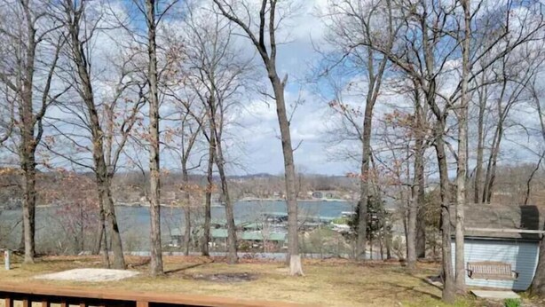 A deck with a view of a lake and trees.