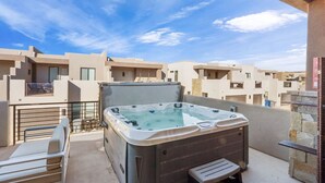Un jacuzzi sur un balcon offrant une vue dégagée sur les bâtiments environnants.