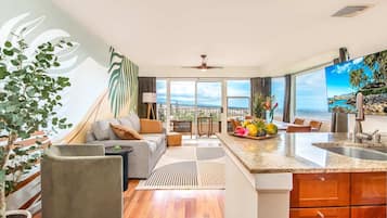 A modern living room with a sofa, coffee table, and a view of the ocean.