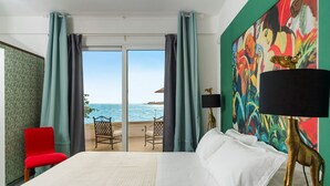 A hotel room with a bed, a red chair, a painting, and a view of the sea. - Jacuzzi and direct access to the sea, Avola -  DiCasaInSIcilia (Avola)