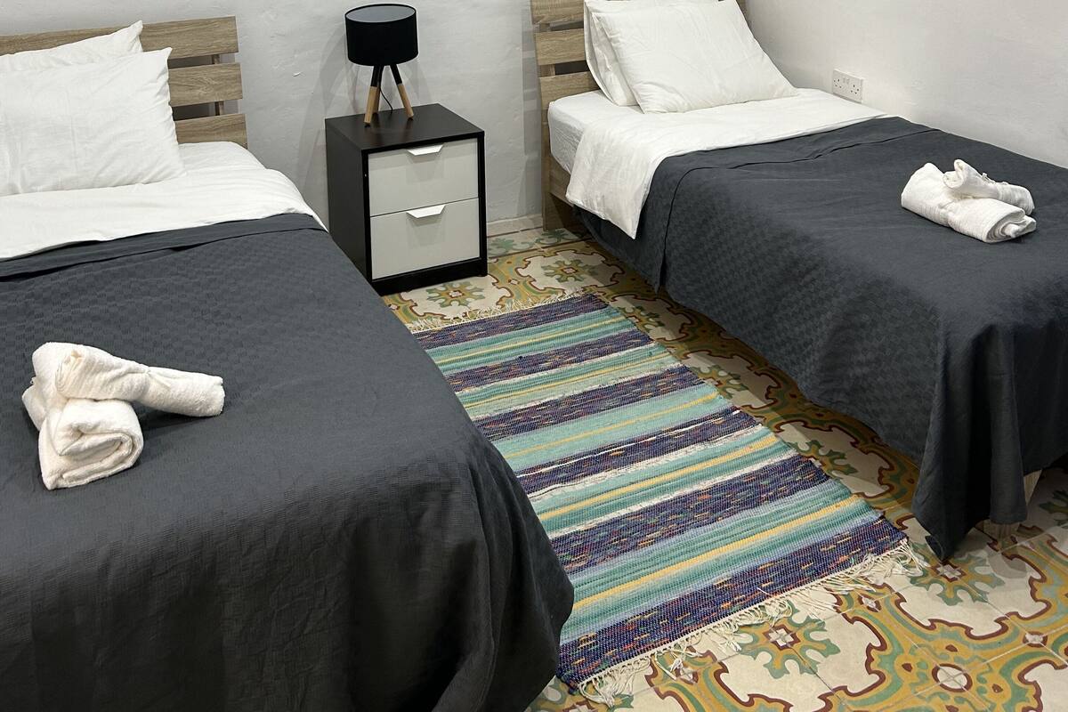 Une chambre d’hôtel avec deux lits, une table de chevet et deux œuvres d’art murales.