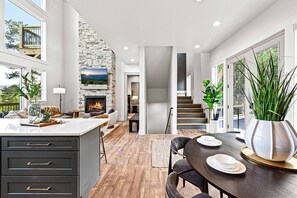 Cozy living space with a central island fireplace, dining area, and seating area.