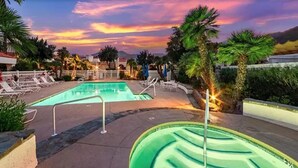 A swimming pool with lounge chairs and palm trees, surrounded by buildings. - The PERFECT Desert Getaway / La Quinta Resort (La Quinta)