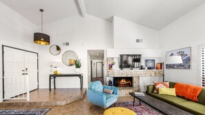 A spacious living room with a fireplace, a sofa, a coffee table, and a blue armchair. - The PERFECT Desert Getaway / La Quinta Resort (La Quinta)