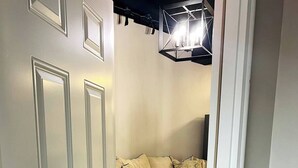 Une pièce avec un canapé beige, un tapis à motifs et un luminaire moderne.