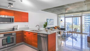 A modern kitchen with stainless steel appliances, wooden cabinets, and a large island. - Stylish 1BR | Free Parking | Walkable Area (Miami)