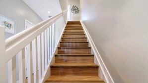 A wooden staircase with white railings and a light-colored wall. - Free Parking | Prime Location Townhouse (Miami)