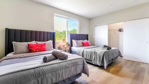 A modern bedroom with two beds, a large window, and a walk-in closet. - Free Parking | Prime Location Townhouse (Miami)