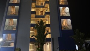 A high-rise building with multiple floors, each with balconies and windows. - Oceanfront Condo with stunning pool and oversized balcony. (Jacó)