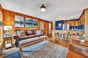 A cozy cabin interior with a wooden interior, a sofa, a dining area, and a kitchen. - 8 Powderidge, Snowshoe, WV - Slopeside Sanctuary (Snowshoe)