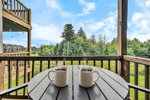 A wooden deck with two white mugs on a table, overlooking a forested area. - 8 Powderidge, Snowshoe, WV - Slopeside Sanctuary (Snowshoe)