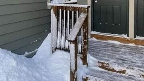 A house with a dark front door, a small porch with a bench, and a number '8' on the door. - 8 Powderidge, Snowshoe, WV - Slopeside Sanctuary (Snowshoe)
