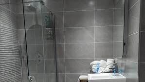A modern bathroom with a glass shower enclosure, a white sink, and a toilet. - Stunning 1-bed Apartment in Rothbury, Morpeth (Morpeth)