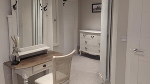 A bedroom with a bed, a dresser, a vanity with a mirror, and a chair. - Stunning 1-bed Apartment in Rothbury, Morpeth (Morpeth)