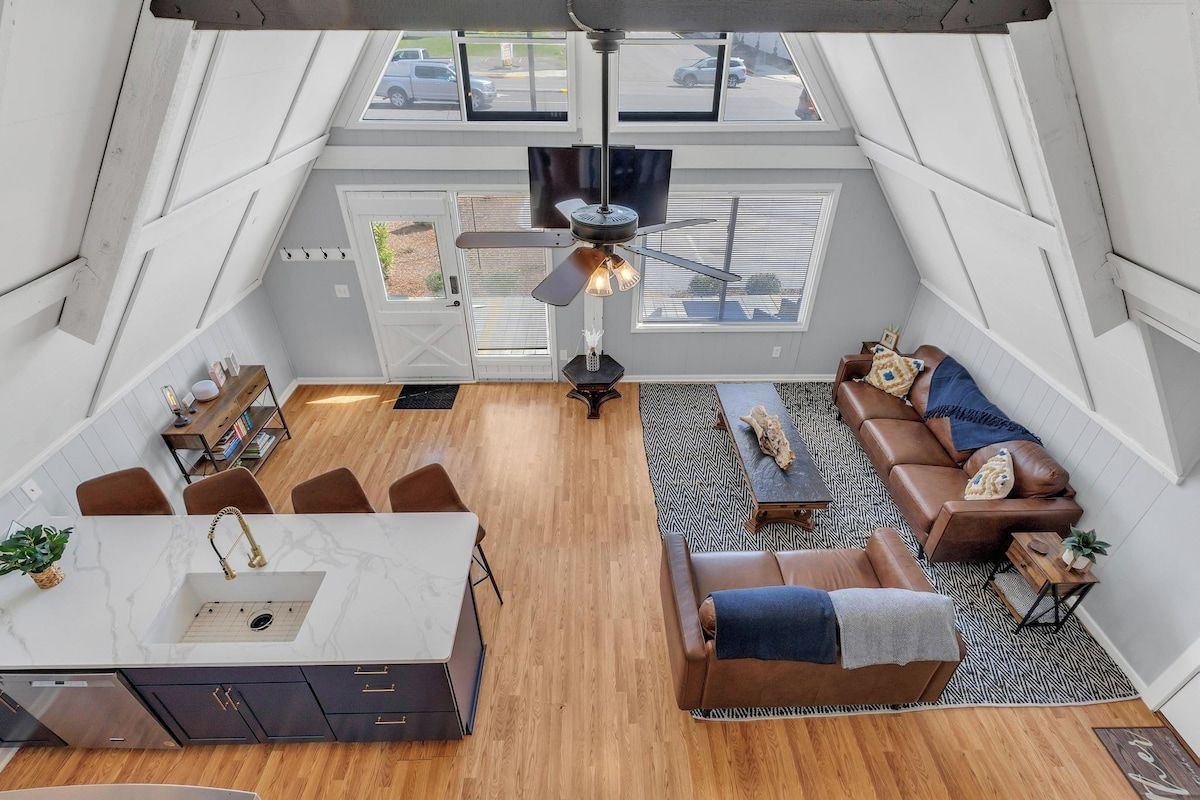 Un loft spacieux comprenant une cuisine, un coin salon et un ventilateur de plafond.