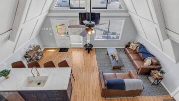 Un loft spacieux comprenant une cuisine, un coin salon et un ventilateur de plafond.