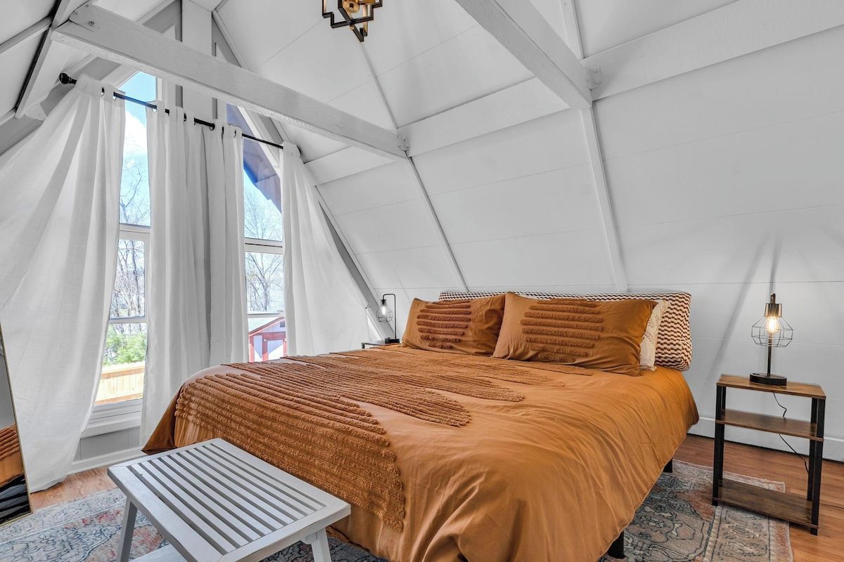 A tented room with a bed, a table, and a lamp.