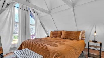 A tented room with a bed, a table, and a lamp.