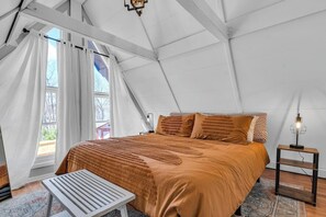 Een tentkamer met een bed, een tafel en een lamp.