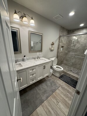 A modern bathroom with a vanity, sink, mirror, and toilet. - 1 min. golf cart ride to the beach! Family-sized house w/ deck & fenced backyard (Panama City Beach)