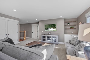 Relax in this stylish living room with a sofa, armchair, and TV.