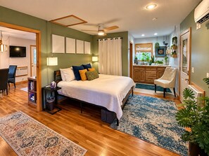 A bedroom with a bed, bedside tables, a desk, and a chair.