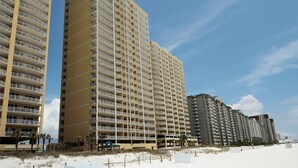 Un hôtel de grande hauteur doté de nombreux balcons, situé près d’une plage.