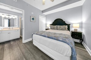 A bedroom with a bed, a nightstand, a dresser, and a mirror. - Tidewater 314 NEW (Panama City Beach)
