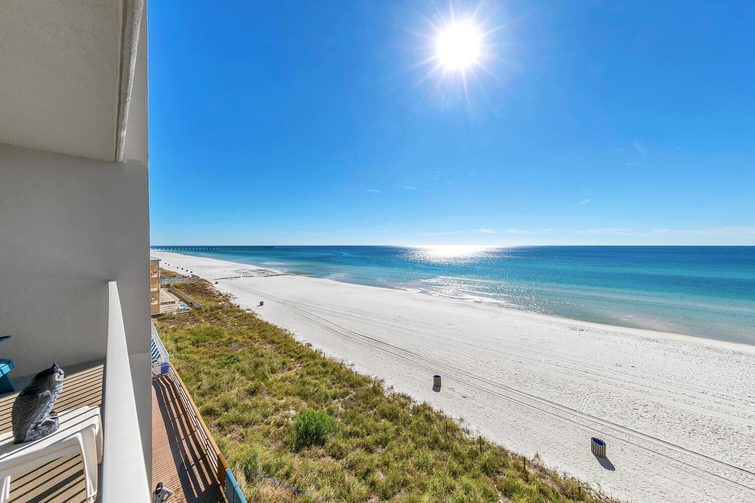 A balcony with a view of a beach and ocean.