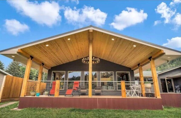 A modern building with a covered patio area, large windows, and a central column. - Private Suite on the Missouri River (Cascade)