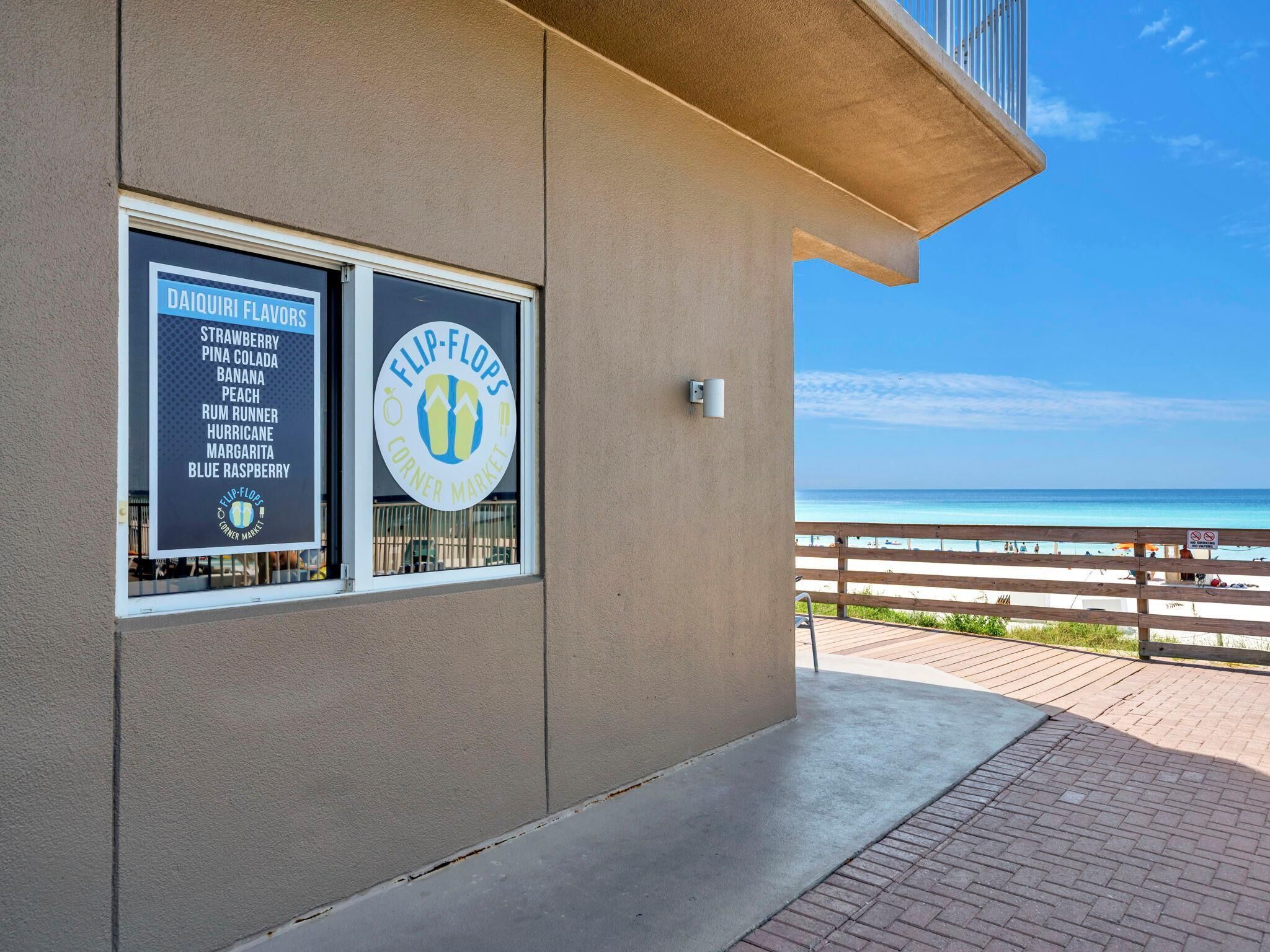 A building with a sign for Daiquiri Flavors and Flip-Flops Corner Market.