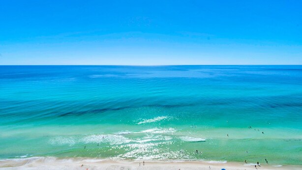 Ein Strand mit klarem türkisblauem Wasser und einem sandigen Ufer.