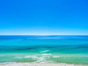 Una playa con aguas turquesas transparentes y una orilla arenosa.