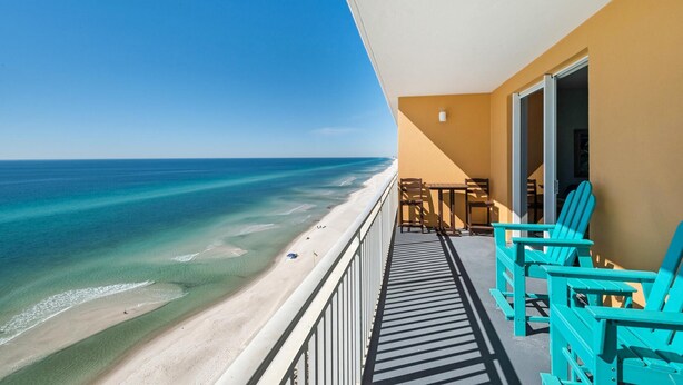 A balcony with turquoise chairs overlooking a beach with clear turquoise water. - Splash 1102e (Panama City Beach)