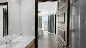 Ein Hotelzimmer mit Bad, Bett und Balkon mit Vorhängen.