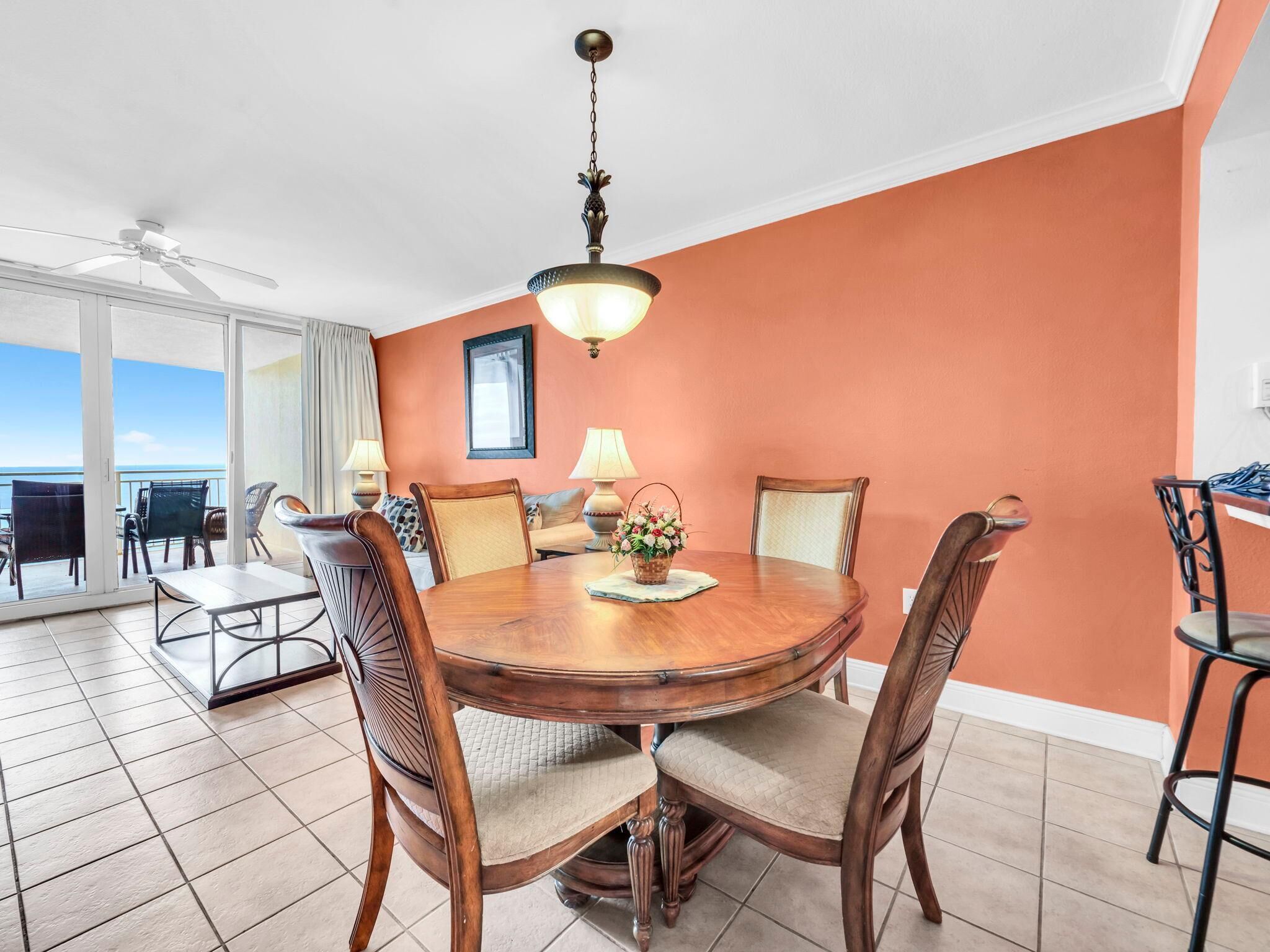 A dining area with a round table, chairs, and a ceiling fan.
