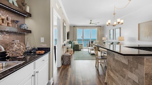 Una cocina moderna con una isla grande, suelo de madera y vistas al exterior.