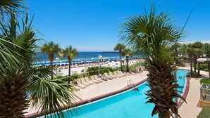 A pool area with lounge chairs and a view of the beach. - Calypso 1-203 East (Panama City Beach)