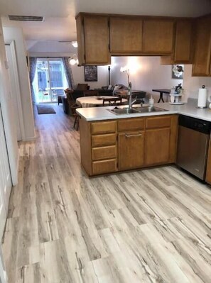 A kitchen with wooden cabinets, a sink, and a dishwasher. - Townhome 2 bed, 2 bath, fenced backyard & garage (Central Point)