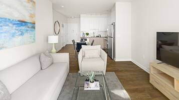 A modern living room with a sofa, a coffee table with a plant, and a TV stand.