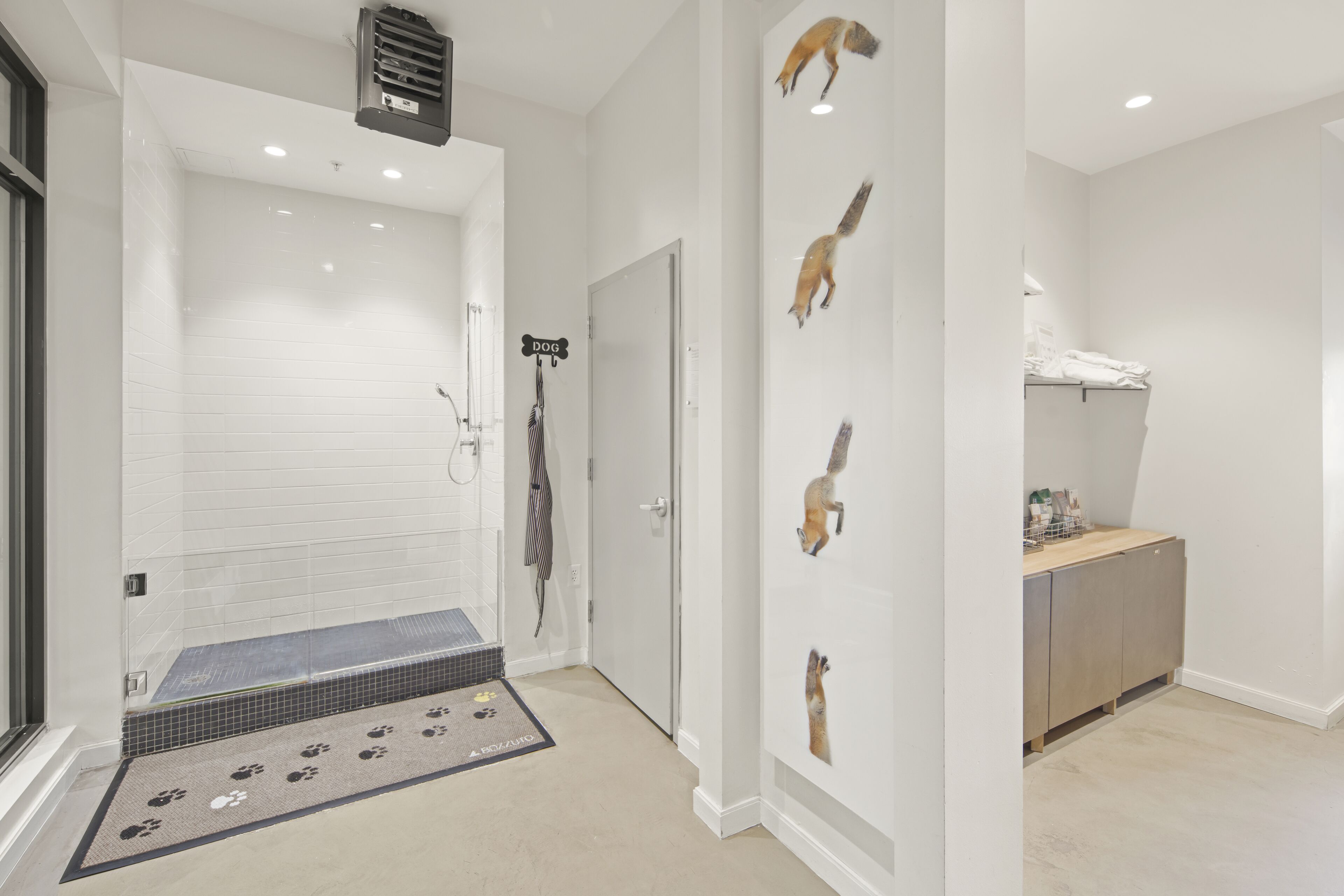 A modern bathroom with a shower, a towel rack, and a wall-mounted towel dispenser.