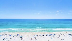 A beach with clear skies, calm sea, and people sunbathing. - Aqua Resort 1007 (Panama City Beach)