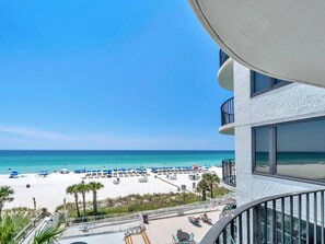 A beach view from a balcony with a pool and lounge chairs. - Watercrest 402 (Panama City Beach)