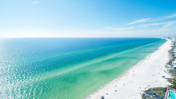 Una playa con aguas turquesas cristalinas y una orilla de arena blanca.